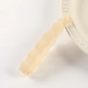 Detail view of the translucent jelly banana hair clip in light beige with wavy minimalist design.