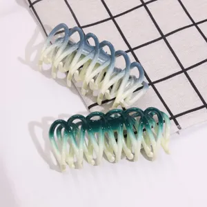 Detailed close-up view of gradient plastic hair claws, featuring blue and green styles.