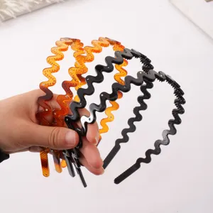 Detailed shot of wavy zigzag headbands with sparkling rhinestones, black and amber colors.