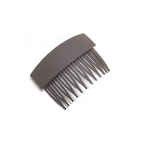 Detailed close up of the dark grey plastic hair insert comb, showing neat teeth and matte texture.
