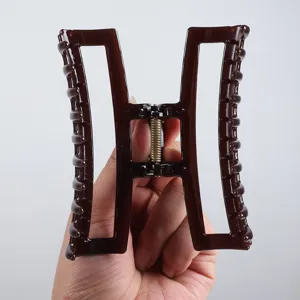 Dunkelbraune geometrische hohle Haarklammer, minimalistisches Design für elegante Frisuren.
