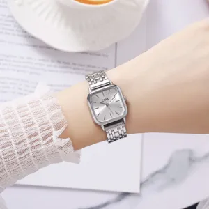 Detalle en primer plano de reloj de mujer cuadrado de cuarzo con correa de acero plateado.