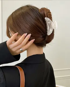 Nahaufnahme Detailansicht der transparenten Acryl Haarklammer mit Strass auf Dutt Frisur.