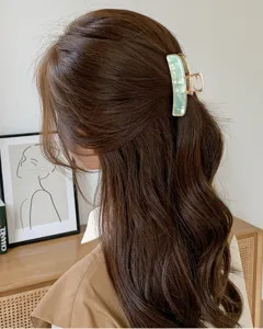 Elegante molletta per capelli in acrilico con bordo metallico, design marmo per acconciatura chic.