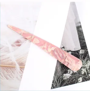 Elegante dettaglio di molletta per capelli lunga in acrilico con texture marmo rosa per styling.