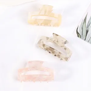 Primo piano sui dettagli dei mini morsetti per capelli cavi, elegante accessorio geometrico.