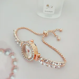 Nahaufnahme einer roségoldenen Strass-Damenarmbanduhr mit verstellbarer Kette und Blättern.