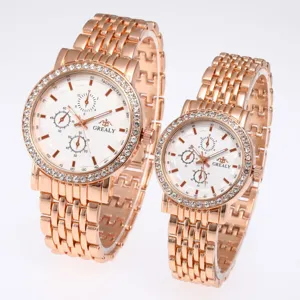 Close-up detail of rose gold couple quartz watches with rhinestone bezels and white dials.