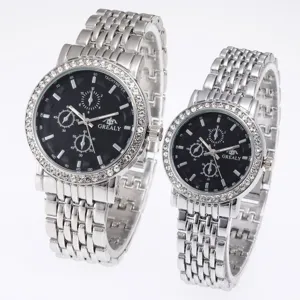 Detail view of silver stainless steel couple quartz watches with black dial and rhinestone bezel.