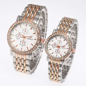 Couple watch detail view featuring rhinestone bezel, dual-tone steel strap and white dial.