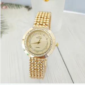 Detail view of the elegant gold quartz women watch featuring a rhinestone bezel and beaded strap.