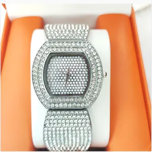 Detailopname van het luxe diamanten tonneau horloge, sprankelende strass brede armband.