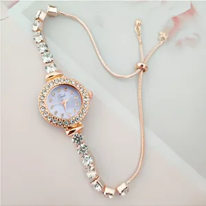 Gros plan sur le détail de la montre femme quartz or rose strass avec bracelet coulissant.