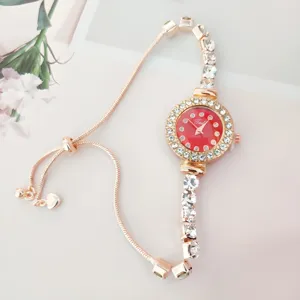 Belle montre bracelet strass pour femme en or rose avec cadran rouge et chaîne réglable.