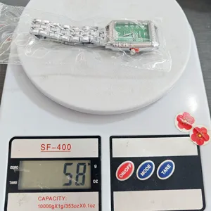 Vue détaillée d'une montre quartz carrée de luxe pour femme avec cadran vert et bracelet acier.