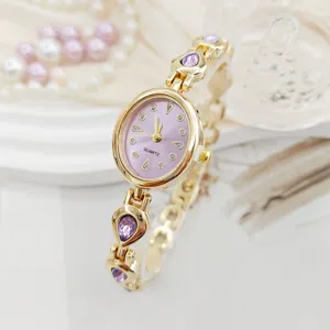Detailed closeup of the elegant women quartz watch featuring purple waterdrop crystals and gold.