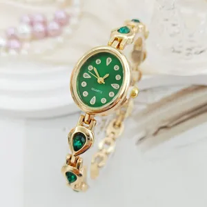 Detail view of luxury green oval dial quartz women watch with sparkling teardrop crystals.