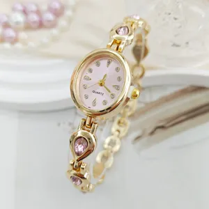 Elegant gold-tone women quartz watch with pink oval dial and teardrop rhinestone bracelet.
