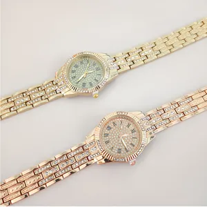 Detail gouden en roségouden strass quartz horloge, Romeinse cijfers wijzerplaat, glanzende stalen band.