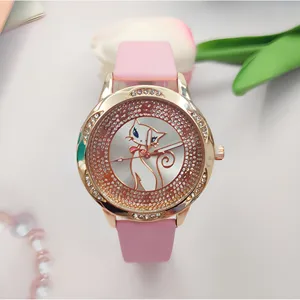 Primo piano di un orologio al quarzo con cinturino rosa, ghiera in strass scintillante e quadrante gatto.