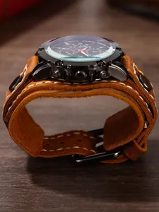 Primo piano dettaglio di orologio al quarzo rétro da uomo con cinturino in pelle marrone e cuciture.