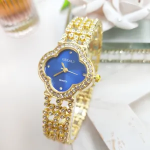 Dettaglio di un orologio al quarzo clover dorato con strass scintillanti e bracciale.