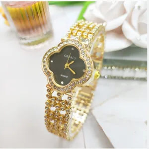 Primo piano di un orologio al quarzo dorato a trifoglio con strass di cristallo sul cinturino.