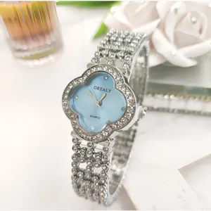 Dettaglio di un orologio al quarzo a trifoglio in strass argentato con quadrante azzurro.