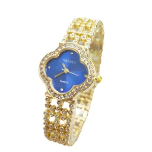Scatto dettagliato dell'orologio donna quarzo quadrante trifoglio blu e bracciale oro.