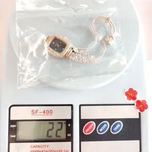 Detailansicht der eleganten Strass-Quadratuhr mit praktischem Zugarmband, auf Waage.