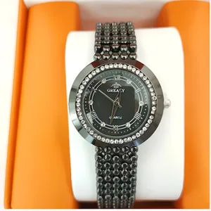Close-up detail of women's quartz watch featuring black dial, rhinestone bezel, and bead strap.