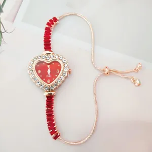 Détail montre quartz strass cœur rouge, bracelet coulissant or rose, design élégant.