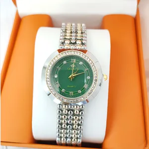 Green dial women quartz watch with diamond bezel, Roman numerals and metal bracelet detail.