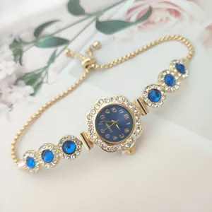 Luxury gold women's quartz watch with blue stones and sparkling rhinestones crystal chain.