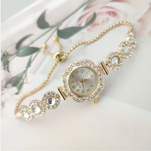 Closeup detail of the elegant gold quartz watch with sparkling rhinestones and a chic pull chain.