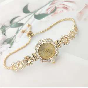 Close up detail of women quartz watch featuring rhinestone floral bezel and adjustable chain strap.