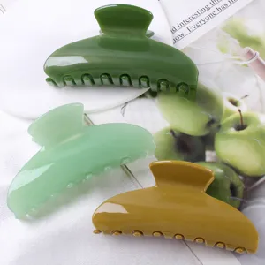 Vista dettagliata di grandi mollette per capelli alla moda da 9.5cm in verde e giallo.