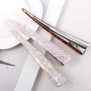 Detailed view of large acrylic hair clips featuring elegant marble and tortoiseshell patterns.