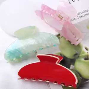 Vista dettagliata di eleganti mollette per capelli in acetato, marmorizzate e tinte unite.