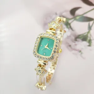 Nahaufnahme Damen Strass Quadrat Quarz Uhr mit grünem Zifferblatt und floralem Armband.