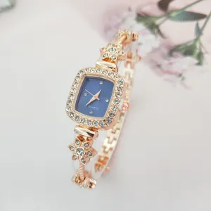 Elegante quadratische Damen Quarzuhr mit funkelnden Strasssteinen und zartem Blumen Armband Design.