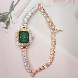 Detailed close-up of square green dial ladies watch with sparkling rhinestone chain strap design.
