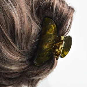 Primo piano della molletta per capelli in acrilico stellato che mostra la sua trama unica.
