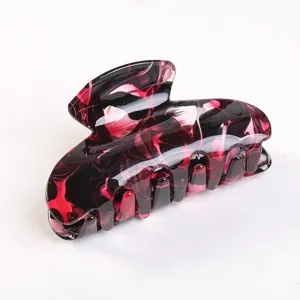 Dettagli del fermaglio per capelli in acrilico marmorizzato rosso e nero, texture squisita.