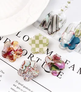 Primo piano dettagliato di mini mollette per capelli a fiore in un elegante allestimento flat lay.