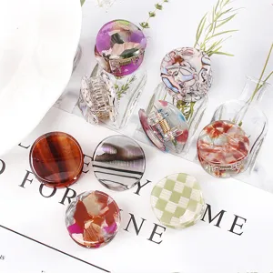 Primo piano di eleganti mini mollette per capelli con vari motivi geometrici per lo styling quotidiano.
