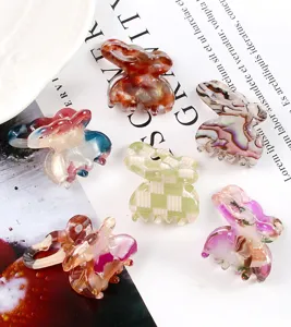 Vista dettagliata di mini mollette per capelli assortite con vari motivi marmorizzati e a quadri.