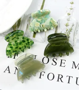 Vista dettagliata di mollette per capelli in acetato verde, design geometrico retrò.