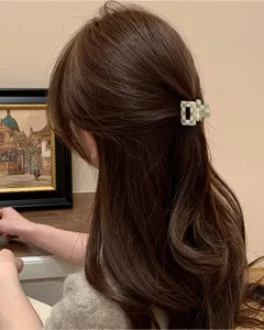 Vista di dettaglio di una mini molletta per capelli a quadri verde e bianco per acconciature.