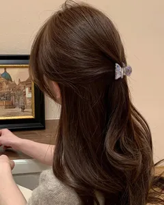 Vue détail d'une mini pince à cheveux géométrique en PVC sur cheveux bruns, accessoire quotidien.